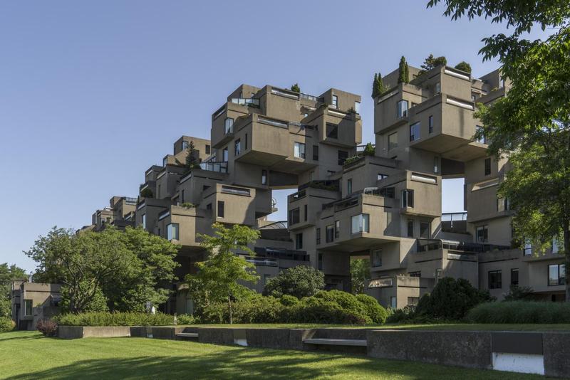blocky cement houses stacked up above greenery