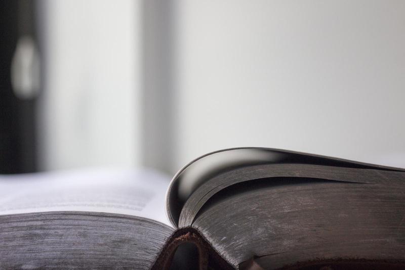 open thick book, viewed from the spine laid flat on a table