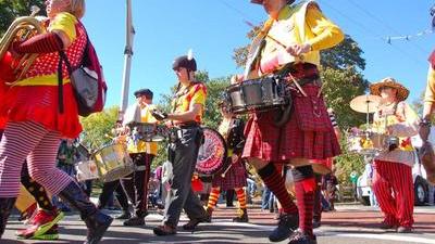 people in a street band marching with drums and kilts and brass