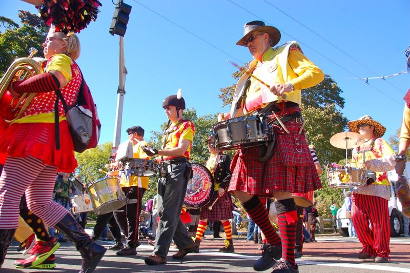 people in a street band marching with drums and kilts and brass