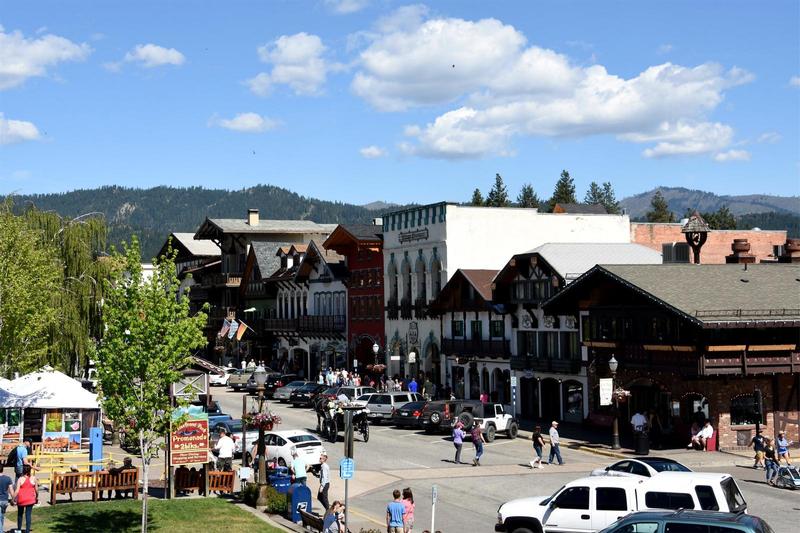 Leavenworth, Washington, a Bavarian themed downtown Main Street with people walking along the street in the sunshine and cars parked along the edges of the road