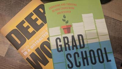the books Deep Work by Cal Newport and Grad School Life by Jacqueline Kory-Westlund stacked up on a table