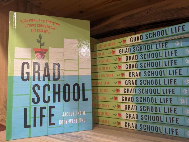 copies of the book Grad School Life on a bookshelf