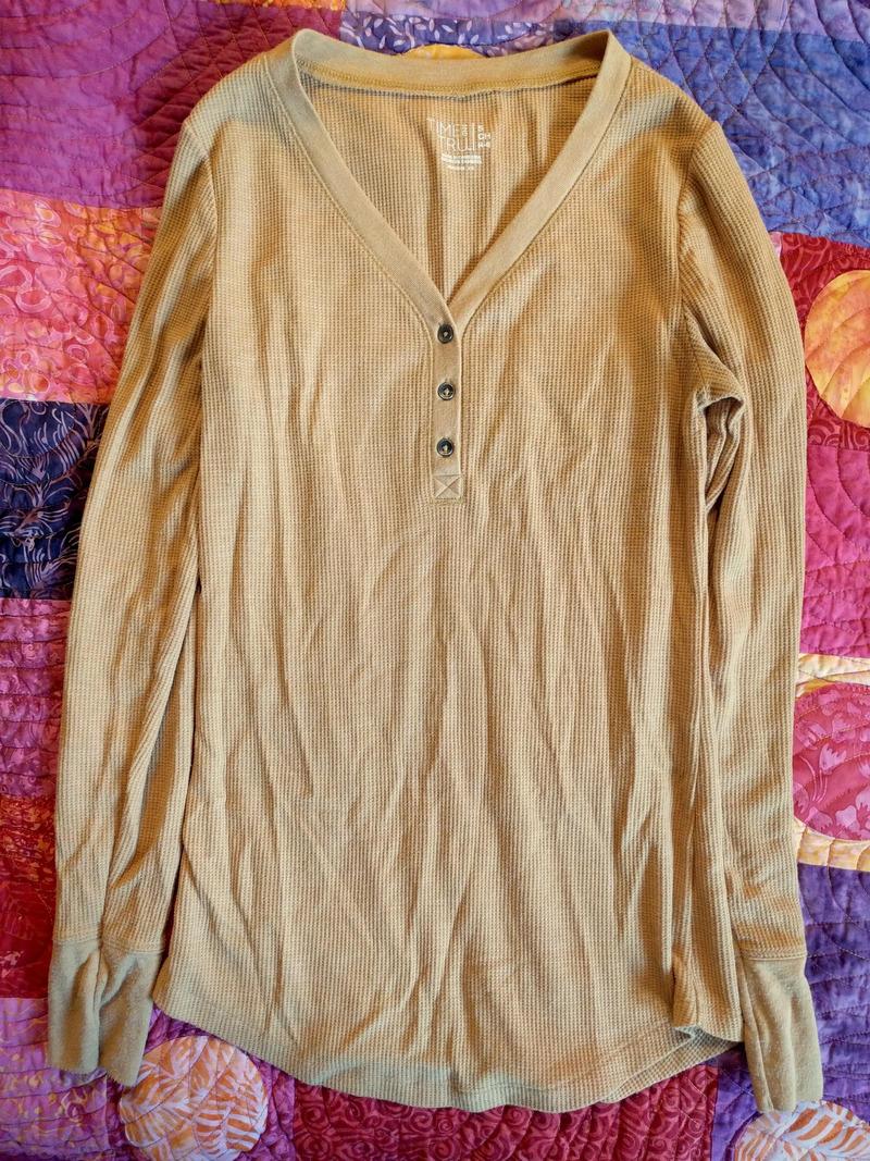 yellow thermal shirt lying on a bed