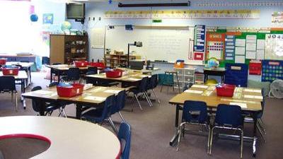 elementary school classroom with desks and whiteboard