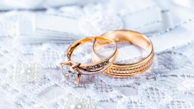 closeup of gold wedding rings on a lace table