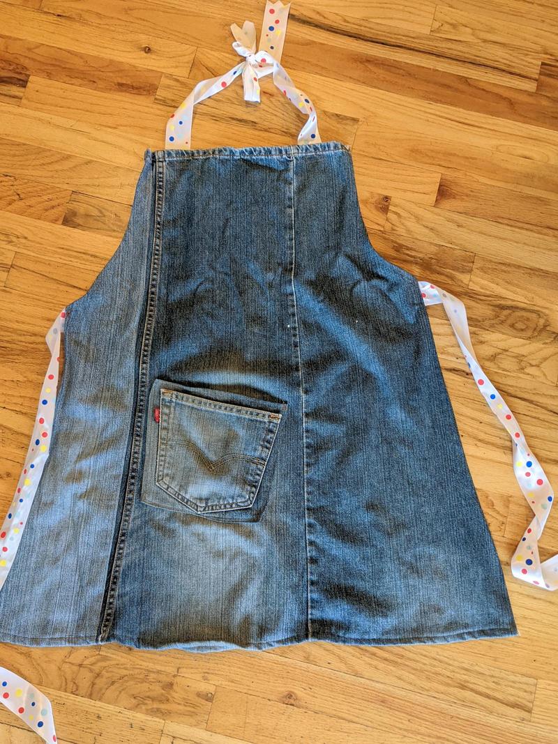 adult size apron made from older blue jeans laying flat on the floor