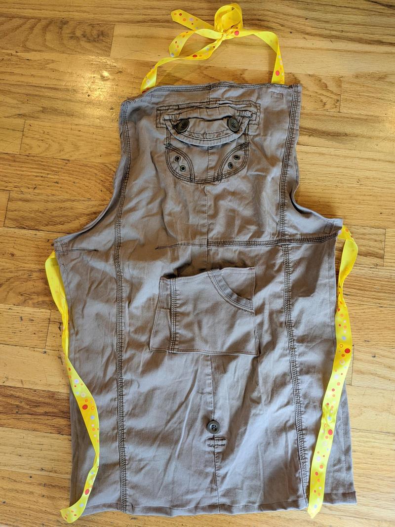 kids size apron made from old brown pants laying flat on the floor