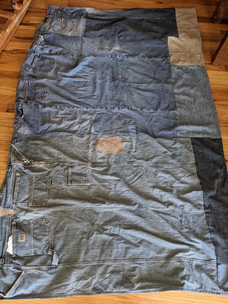 a picnic blanket made from old blue jeans, laid flat on the floor