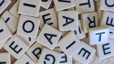 a pile of small letter tiles with black uppercase letters on them