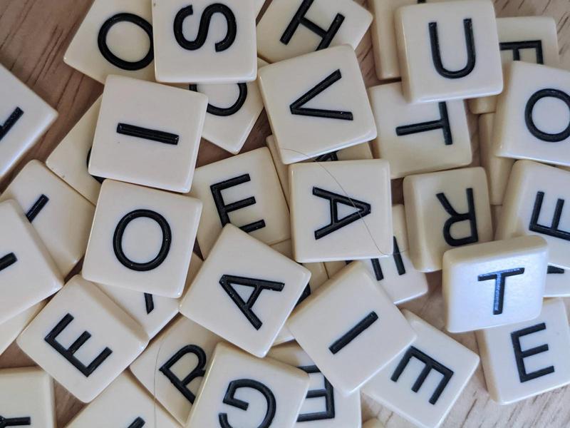 a pile of small letter tiles with black uppercase letters on them