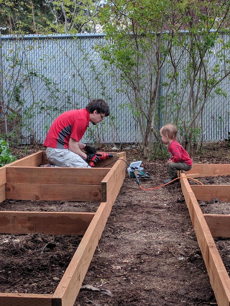 Randy and Elian screwing boards together for raised garden beds