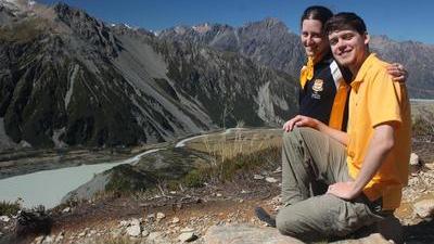 Randy and Jacqueline sit on a mountain in New Zealand