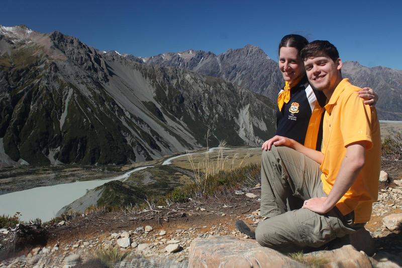 Randy and Jacqueline sit on a mountain in New Zealand