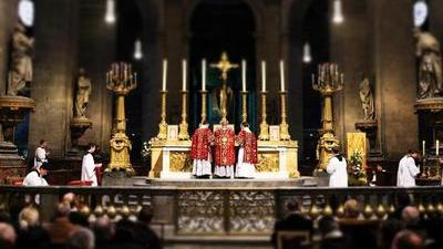 Priests in red and gold celebrate a traditional Latin Mass