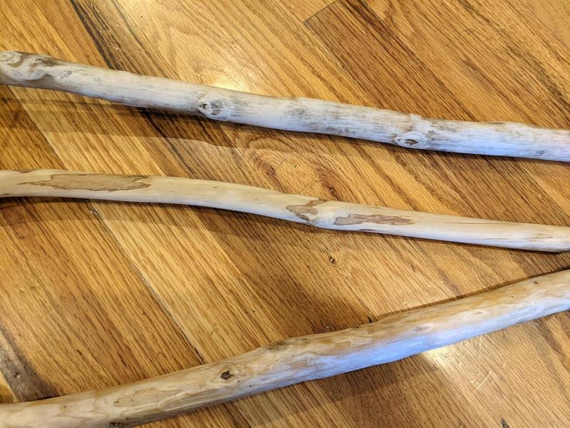 three sanded wooden sticks, each about an inch thick, lying on the floor