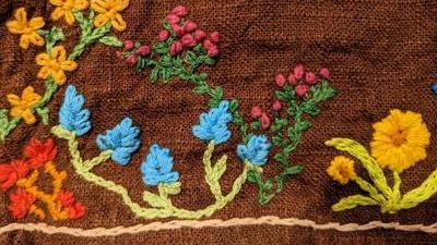 close up of embroidered flowers on the edge of a linen skirt