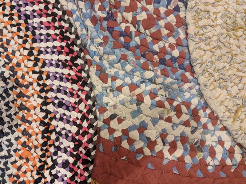 Several braided rag rugs stacked on top of each other