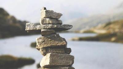 a rock cairn of angular stones with a river blurred in the background