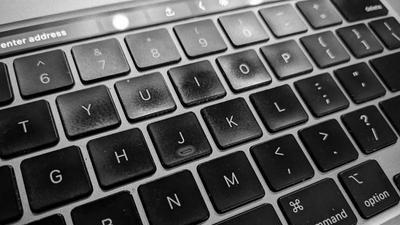 closeup of a black-keyed macbook keyboard viewed at an angle