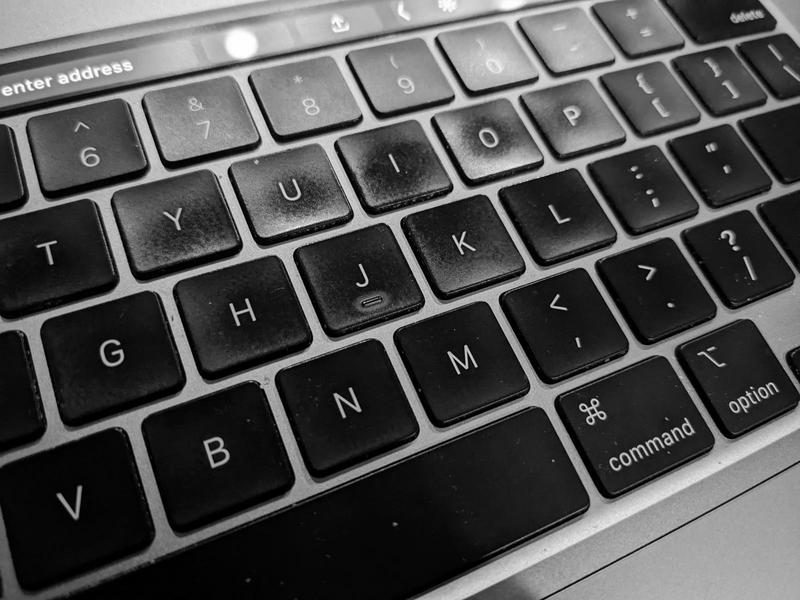 closeup of a black-keyed macbook keyboard viewed at an angle