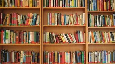 three wooden bookshelves filled with books