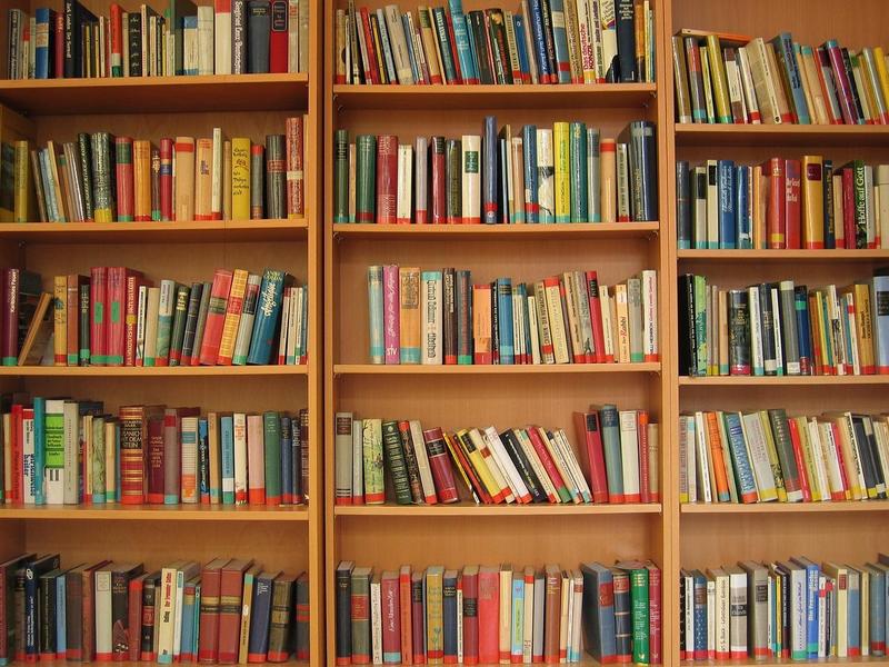 three wooden bookshelves filled with books