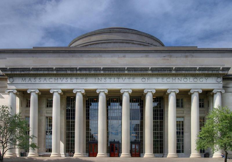 an academic building in classical style with a bunch of columns and a rounded down on top with roman lettering saying massachusetts institute of technology