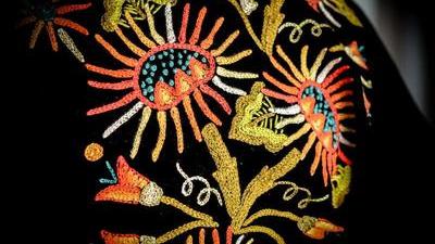 close up of embroidered flowers on black fabric