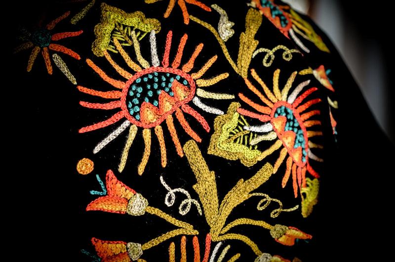 close up of embroidered flowers on black fabric